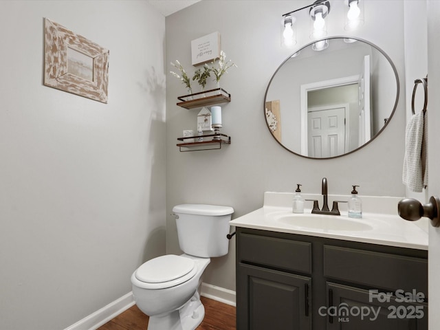 bathroom with toilet, vanity, and hardwood / wood-style flooring