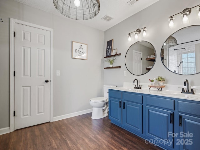 bathroom featuring toilet, a textured ceiling, walk in shower, wood-type flooring, and vanity