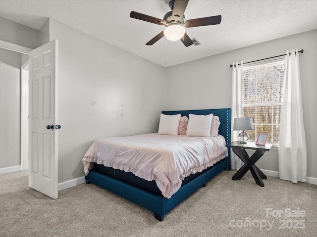 bedroom with carpet floors, ceiling fan, and a textured ceiling