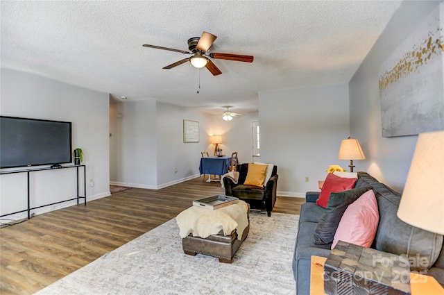 living room featuring a textured ceiling, hardwood / wood-style flooring, and ceiling fan