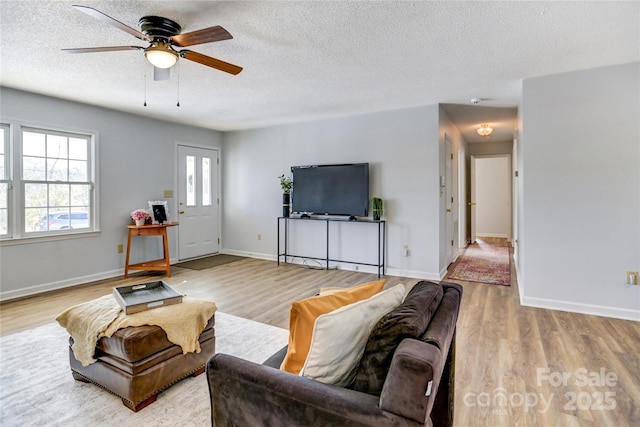 living room featuring wood-type flooring, a textured ceiling, and ceiling fan