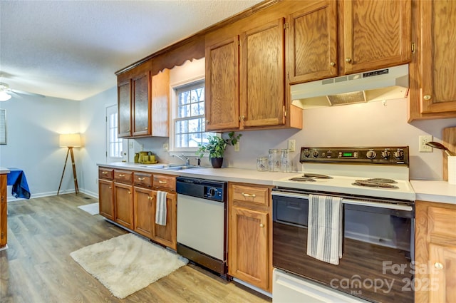 kitchen with ceiling fan, sink, white appliances, and light wood-type flooring