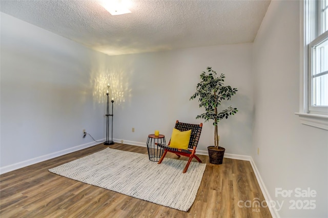 sitting room with hardwood / wood-style floors and a textured ceiling