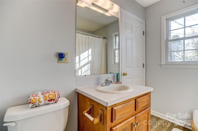 bathroom with vanity, toilet, and a healthy amount of sunlight