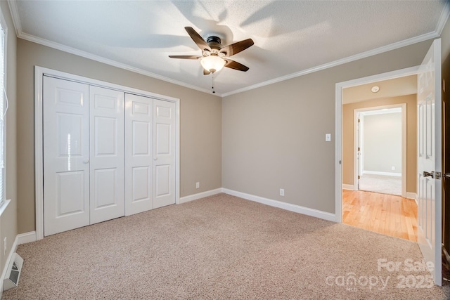 unfurnished bedroom featuring carpet, ceiling fan, and crown molding