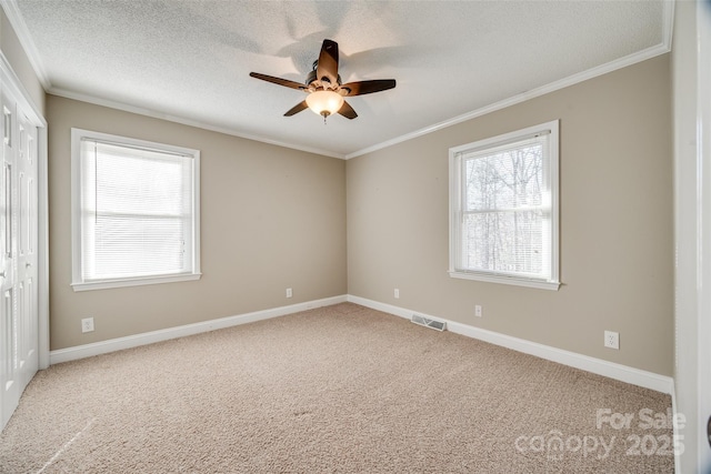 unfurnished room with carpet flooring, a textured ceiling, ceiling fan, and crown molding