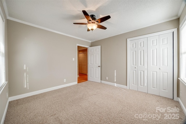 unfurnished bedroom featuring carpet floors, ceiling fan, and crown molding