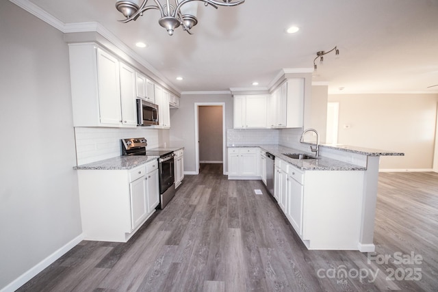 kitchen featuring kitchen peninsula, appliances with stainless steel finishes, white cabinets, and sink