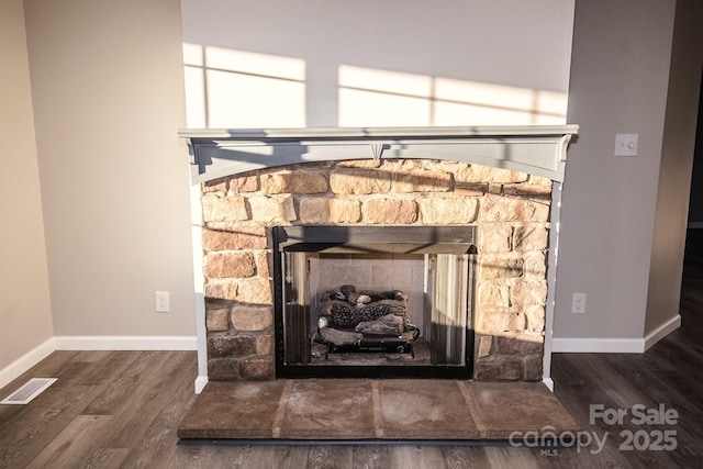 interior details with hardwood / wood-style flooring and a stone fireplace