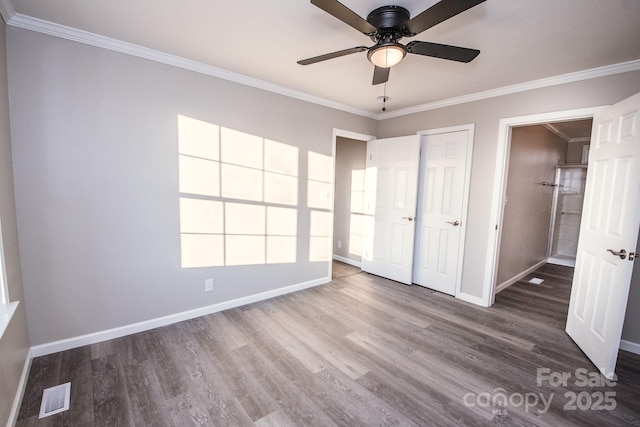 unfurnished bedroom featuring hardwood / wood-style floors, ceiling fan, ornamental molding, and a closet