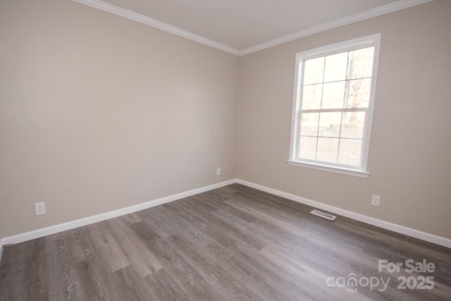 spare room with a wealth of natural light, hardwood / wood-style floors, and ornamental molding