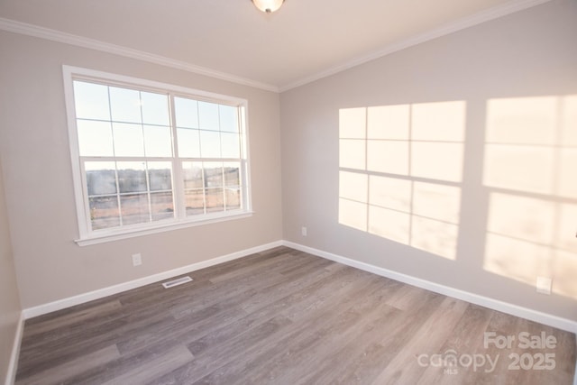 empty room featuring hardwood / wood-style floors and ornamental molding