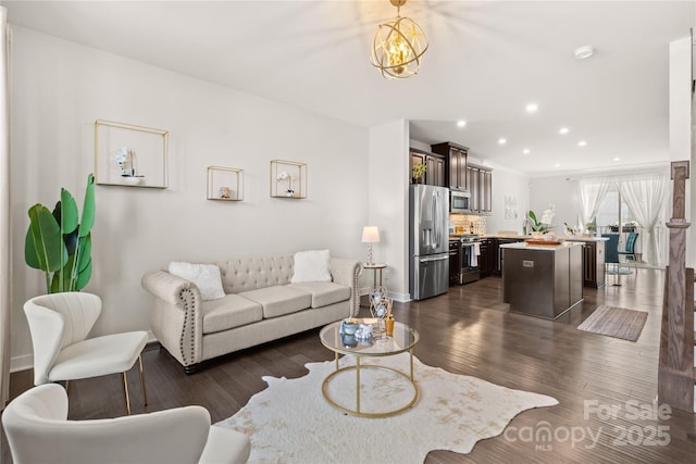 living room featuring recessed lighting, dark wood finished floors, and an inviting chandelier