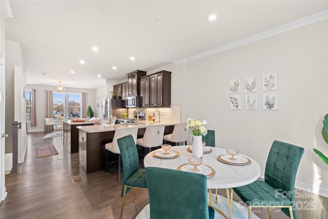 dining room with baseboards, wood finished floors, and recessed lighting