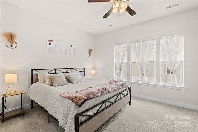 bedroom featuring a ceiling fan, light colored carpet, visible vents, and baseboards