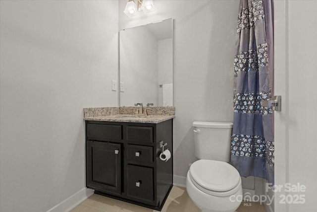 bathroom featuring toilet, baseboards, and vanity