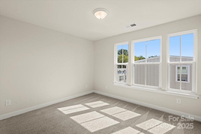 carpeted empty room with baseboards and visible vents