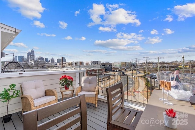 wooden terrace with a view of city and outdoor lounge area