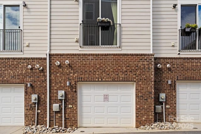 exterior space with a garage and brick siding