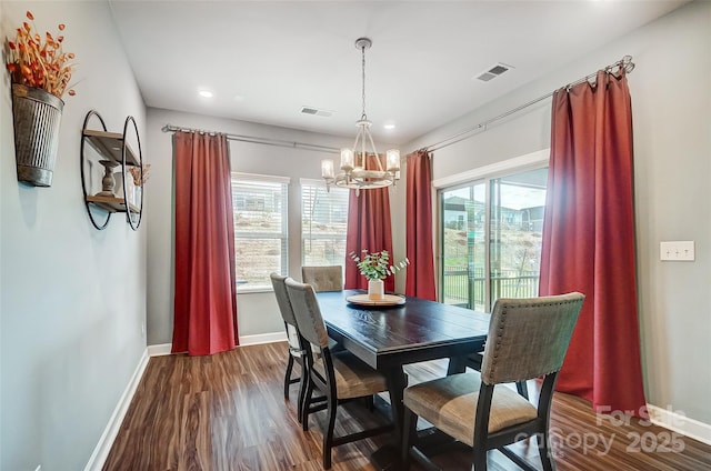 dining space featuring dark hardwood / wood-style floors and an inviting chandelier