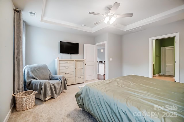 bedroom with ceiling fan, a raised ceiling, and light carpet