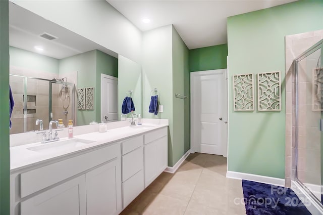 bathroom with tile patterned floors, a shower with door, and vanity