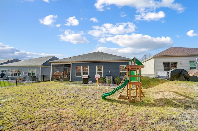 rear view of property featuring a yard and a playground