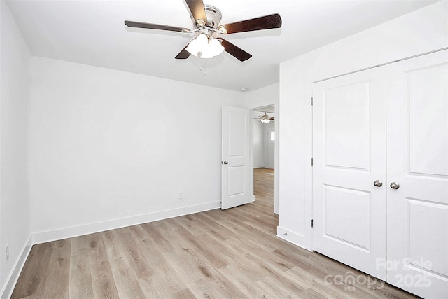 unfurnished bedroom with ceiling fan, a closet, and light wood-type flooring