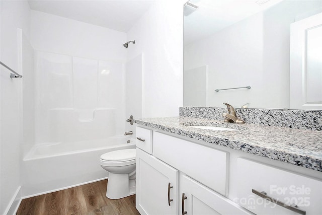 full bathroom with toilet,  shower combination, hardwood / wood-style floors, and vanity