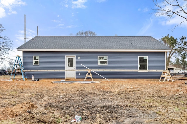 back of property with a shingled roof