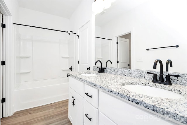 2365 28th St NE, Hickory, NC 28601 - bathroom featuring double vanity, tub / shower combination, a sink, and wood finished floors
