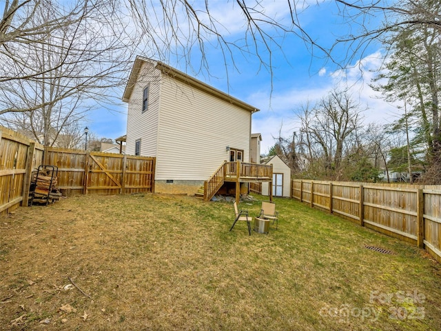 back of property featuring a yard, a shed, and a wooden deck