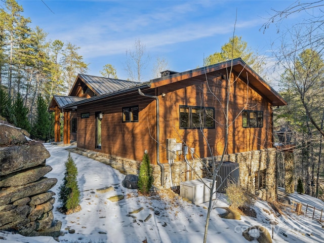 view of snowy exterior featuring central AC