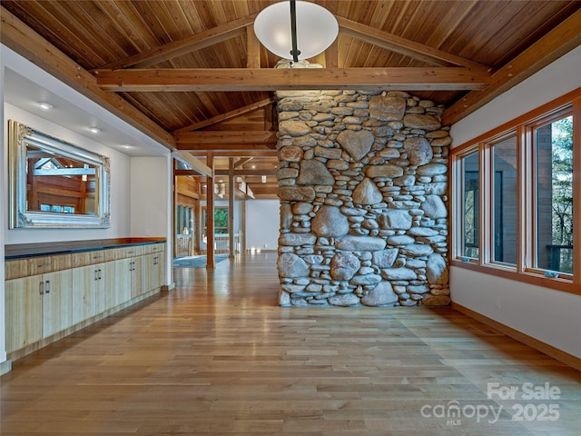 interior space featuring beam ceiling, light wood-type flooring, and wooden ceiling