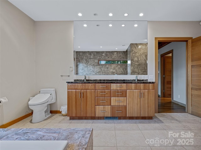 bathroom featuring toilet, vanity, and tile patterned flooring