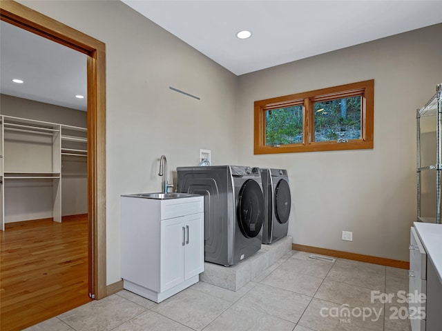 washroom featuring cabinets, light tile patterned floors, sink, and washer and dryer