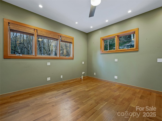 empty room featuring ceiling fan, light hardwood / wood-style floors, and plenty of natural light