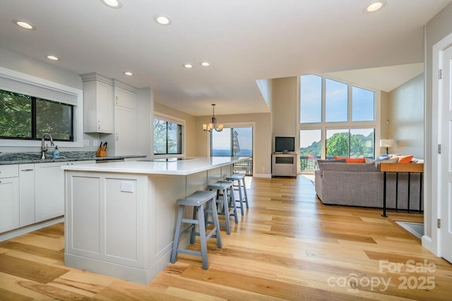 kitchen with a chandelier, a center island, decorative light fixtures, and white cabinetry