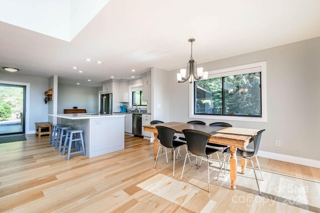 dining area featuring light hardwood / wood-style flooring and a notable chandelier