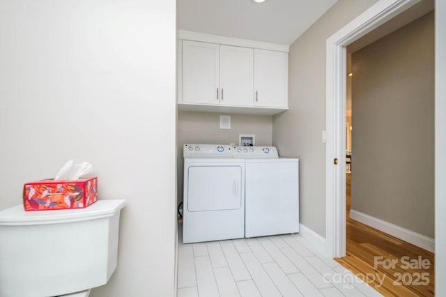 laundry room with washer and dryer and cabinets