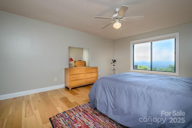 bedroom with ceiling fan and wood-type flooring