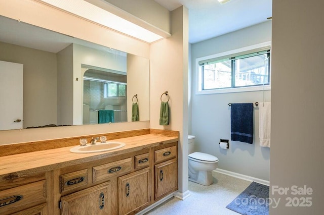 bathroom featuring walk in shower, vanity, and toilet