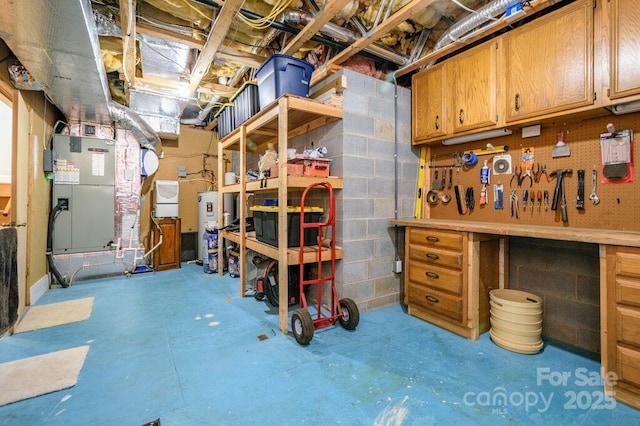 basement featuring a workshop area, water heater, and heating unit