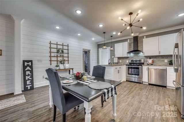 dining space with an inviting chandelier, light hardwood / wood-style flooring, and sink