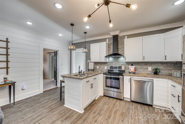 kitchen featuring kitchen peninsula, stainless steel electric range, wall chimney range hood, and white cabinetry