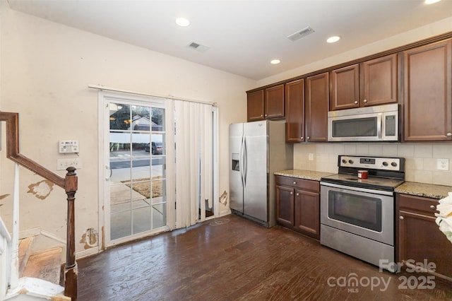 kitchen featuring dark hardwood / wood-style floors, decorative backsplash, light stone counters, dark brown cabinetry, and stainless steel appliances