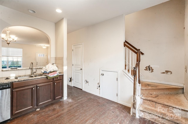 kitchen with dishwasher, sink, light stone countertops, dark hardwood / wood-style flooring, and dark brown cabinetry