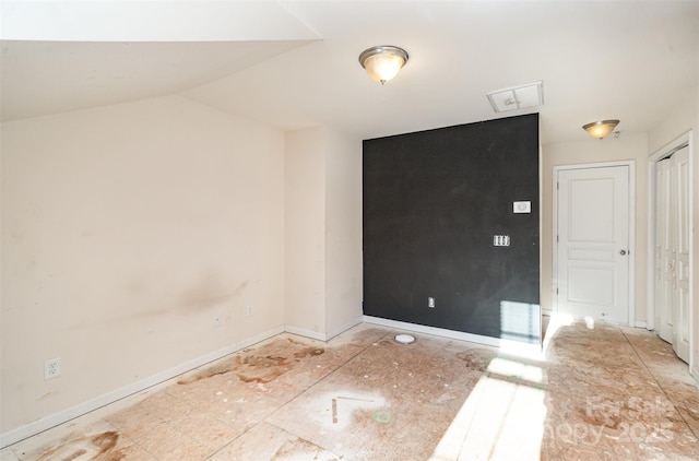 spare room featuring lofted ceiling