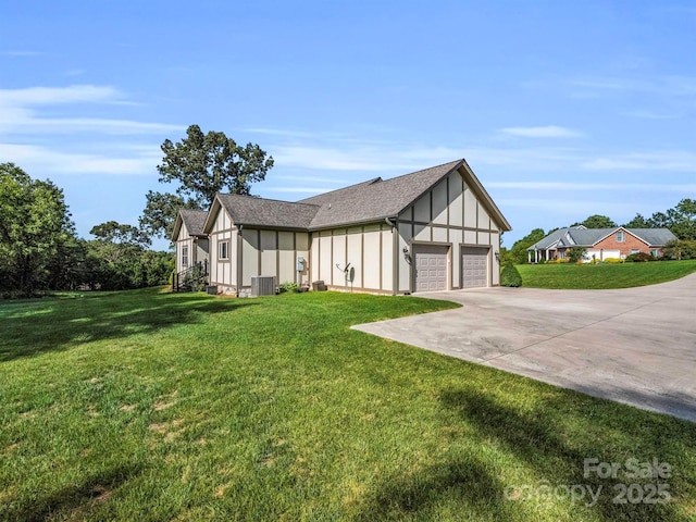 view of side of home featuring a lawn, a garage, and central air condition unit