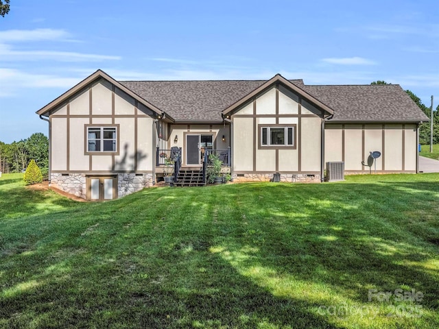 rear view of house featuring central AC and a lawn